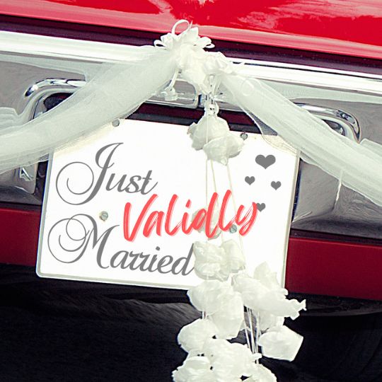 Just
                              Validly Married Sign on the back of a red
                              car. Decorated with swathes of cream
                              tulle, and white flowers